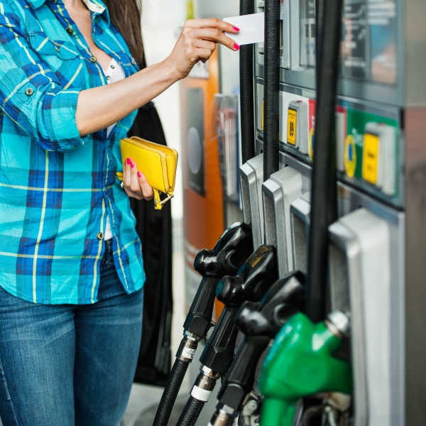 woman at gas pump paying with credit card