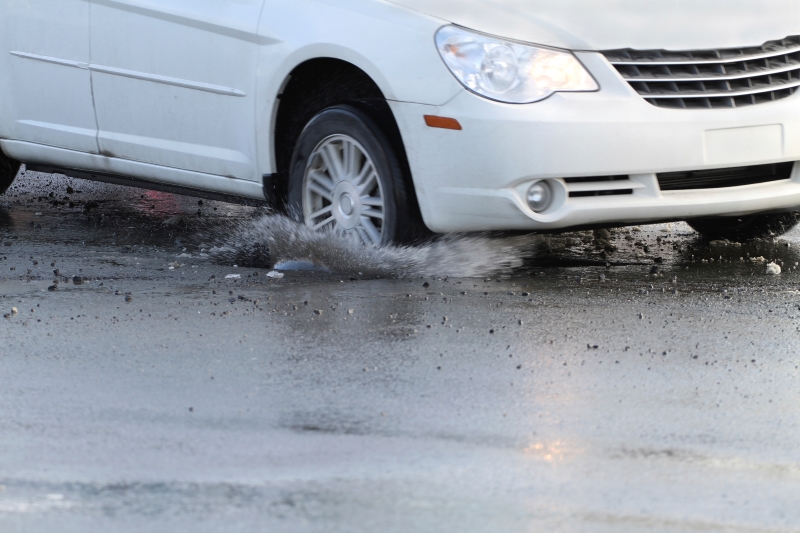 car hitting pot hole